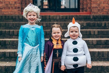 Three kids dressed up as Elsa, Anna and Olaf from Frozen.