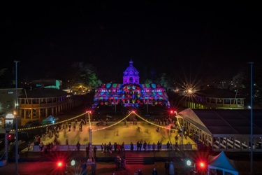 Aerial view of the illuminated Bathurst Courthouse and ice rink at night.