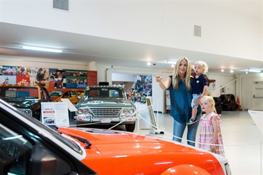 Mum and two children looking at the historic cars at the National Motor Racing Museum.