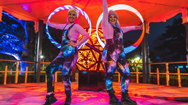 LED hoola hooper performers posing for the camera with their lit up hoops.