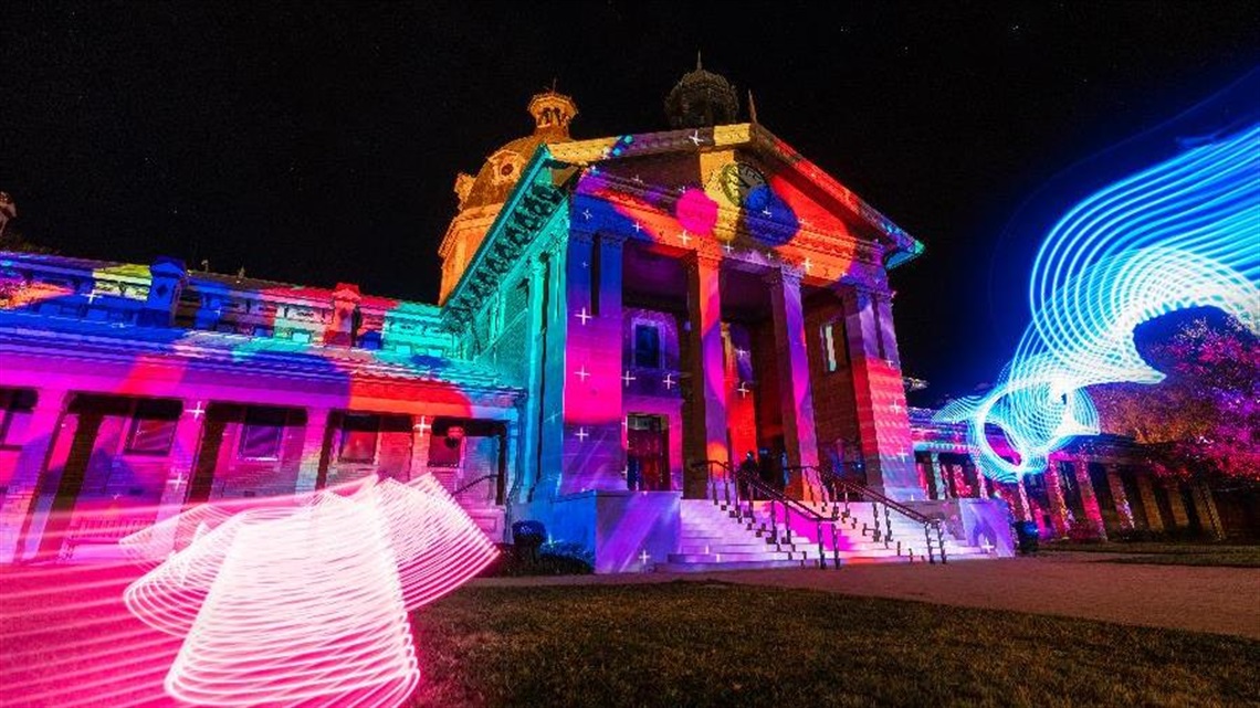 Bathurst Courthouse covered in bright colours as it's illuminated.