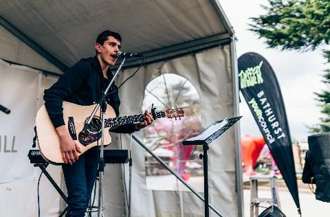 Young musician playing on the Bowman Dental Stage at the festival.