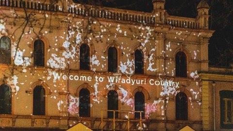 Historic Webb and Co building illuminated with an Indigenous artwork projection and the words 'Welcome to Wiradjuri Country'.