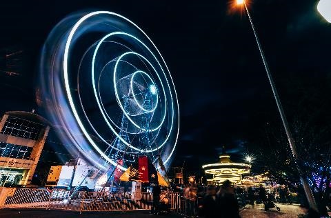 Giant Ferris wheel lit up at night.